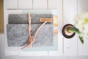 top-down view of a grey felt journal labeled "to do list" with a plant beside it on a table